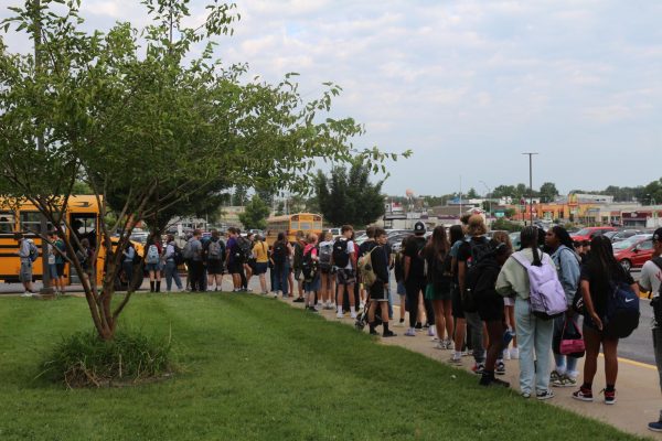 Students line up down the sidewalk back to Business Loop to get through the detection systems and into the building on Aug. 21.