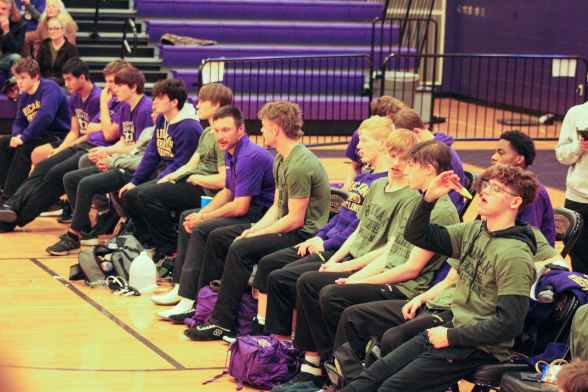 Members of the Hickman wrestling team watch their teammates compete during the Duel Meet.