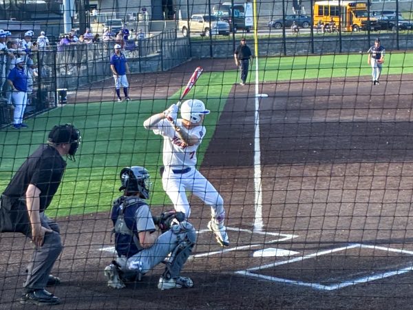 Kolton Crane (11) begins to swing in the first of the two-game matchup against the crosstown rival, Battle