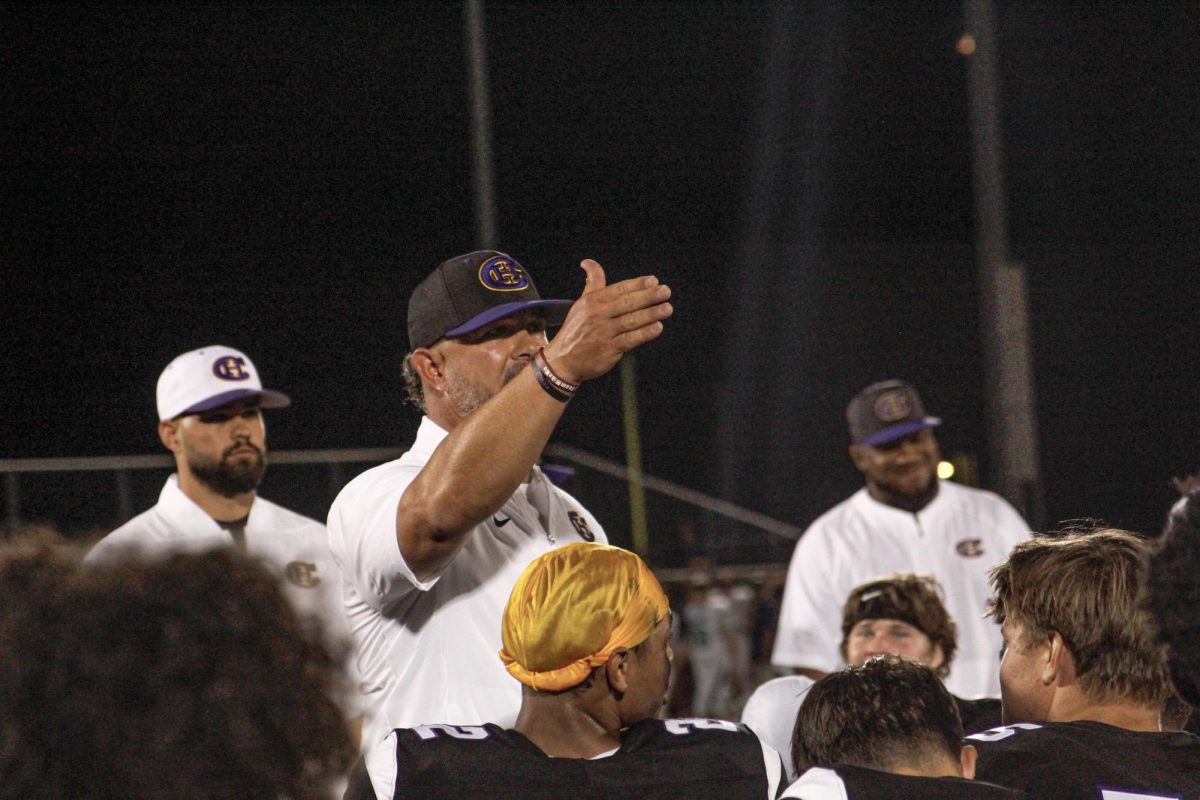 Coach Justin Conyers talking to his team after winning their season opener against Marquette High School, 48-14