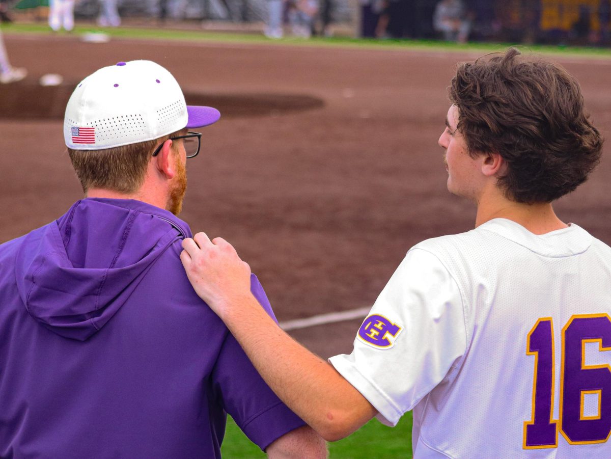 Coach Andrew Guise and Colton Nichols (11) talk between innings during the beginning of Hickman's 15-inning thriller against Capital City on March 31. Hickman won the game 7-5 with a walk-off three-run double by Landen Durnil (12) during the bottom of the 15th.
